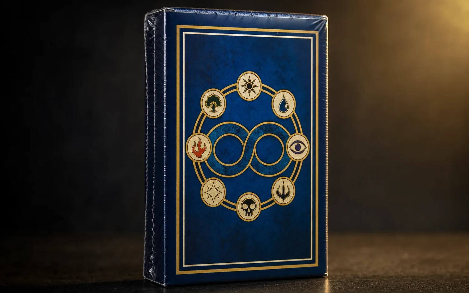 Eine dunkelblaue Sammelbox mit goldenem Rahmen und Symbolring, aufrecht stehend vor dunklem Hintergrund.