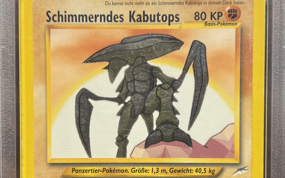 Eine deutsche Karte Schimmerndes Kabutops aus Neo Destiny im PSA-Gehäuse, oben die Regel, dass nur ein Schimmerndes Kabutops im Deck erlaubt ist, darunter das glänzende Kartenbild.