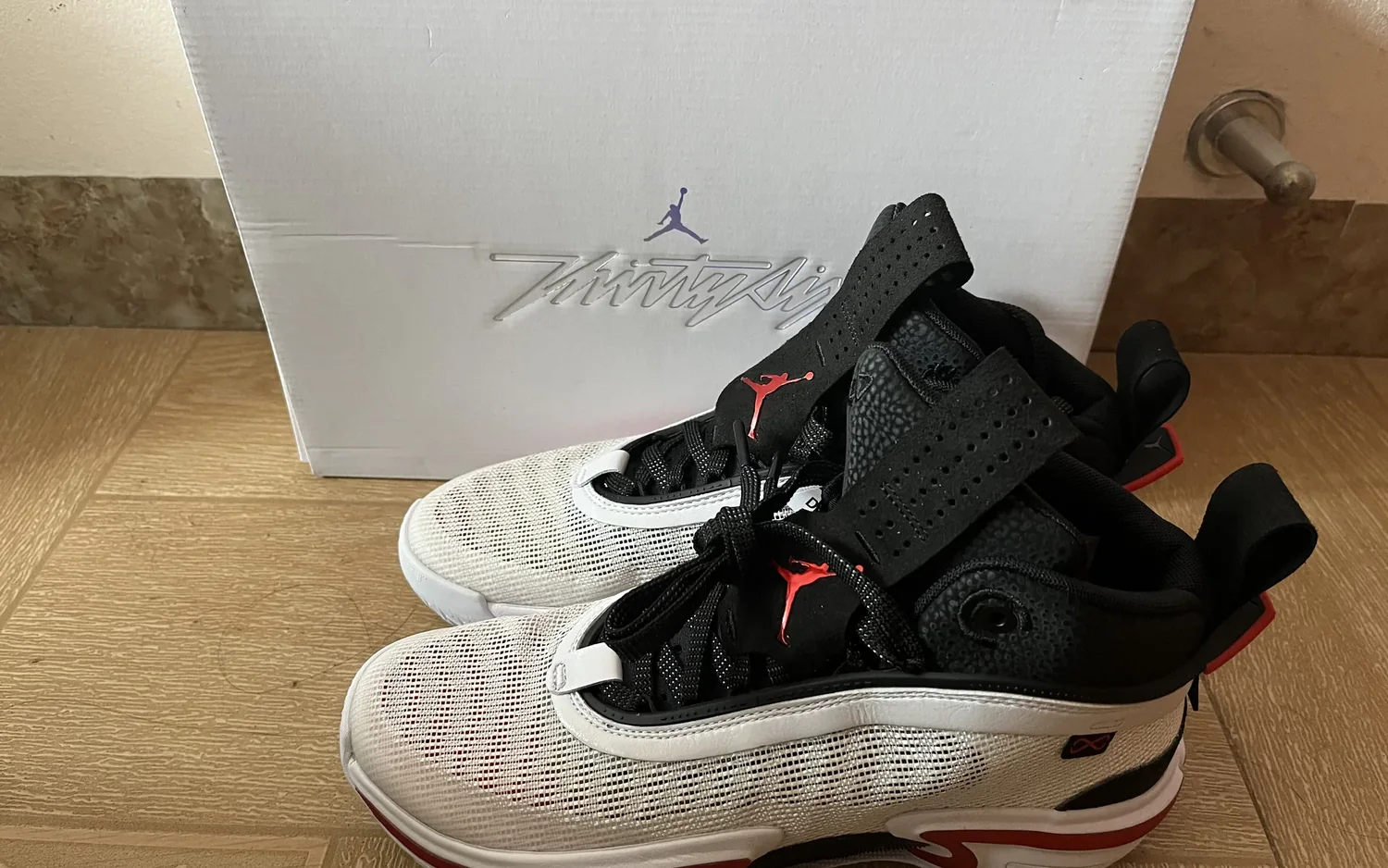 Ein Paar Basketballschuhe steht vor dem geöffneten Schuhkarton, das Etikett des Kartons ist sichtbar.