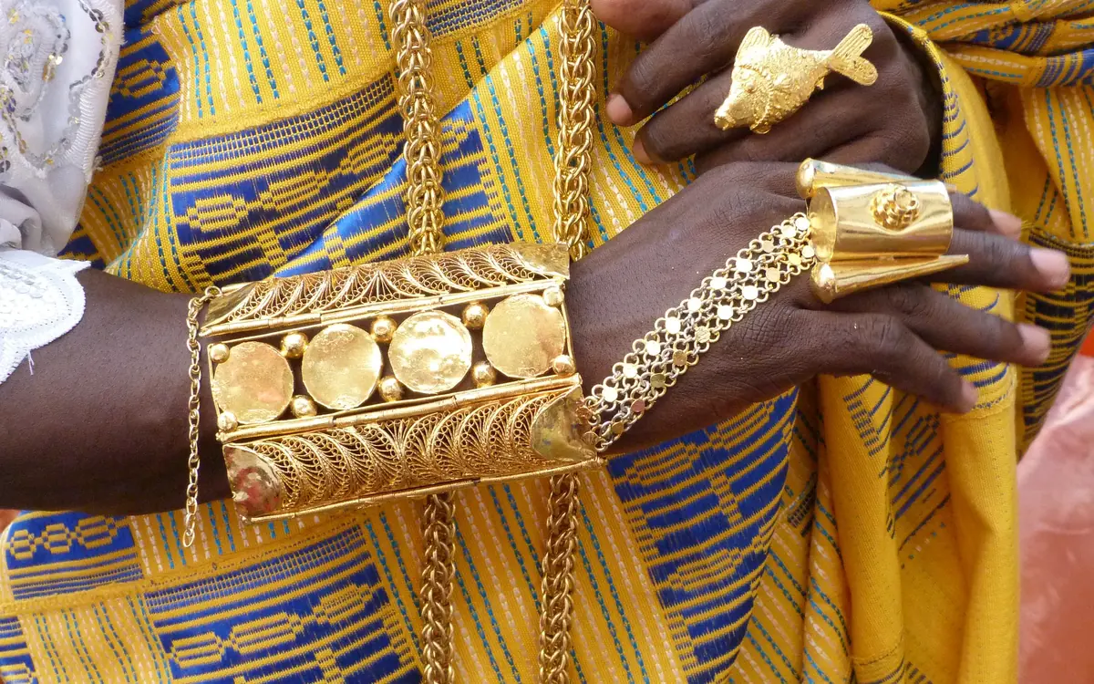 Goldschmuck mit Filigranarbeit an Händen mit traditionellem Gewand