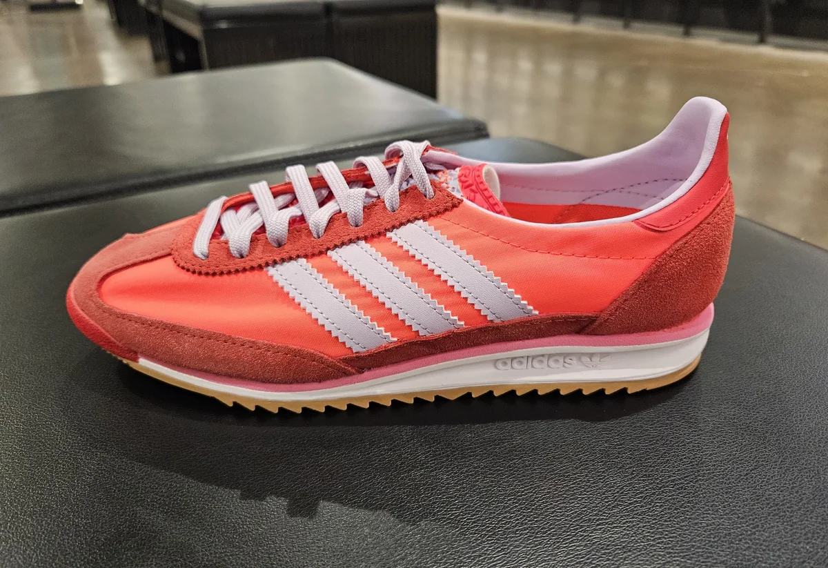 Retro-Laufschuh in Orange mit hellen Streifen auf der Ladentheke