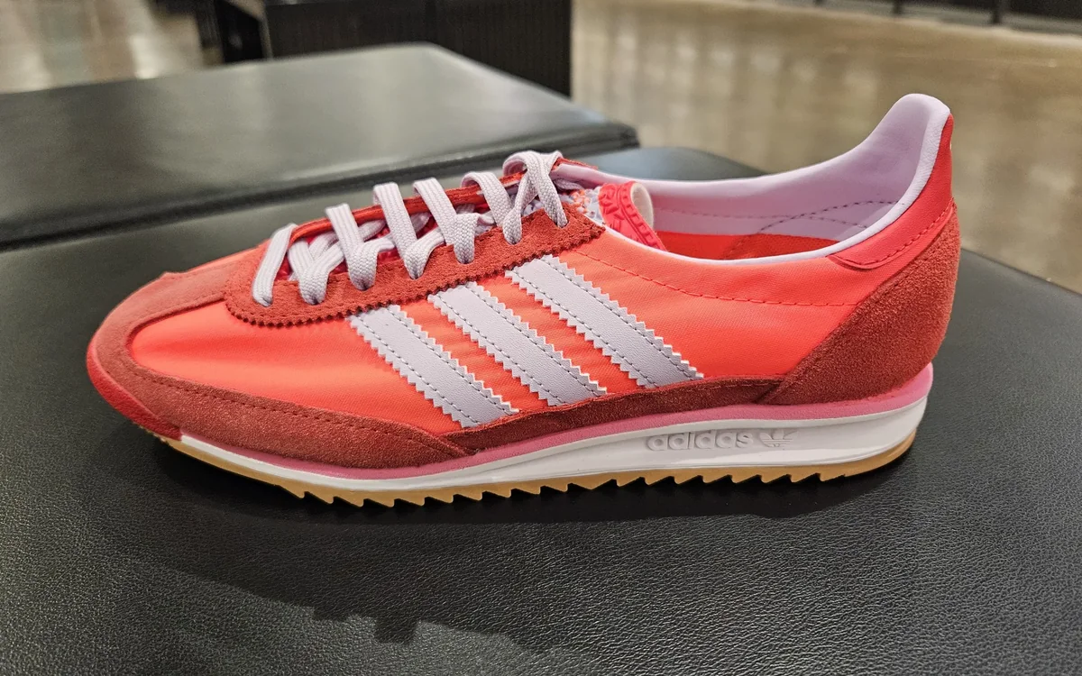 Retro-Laufschuh in Orange mit hellen Streifen auf der Ladentheke