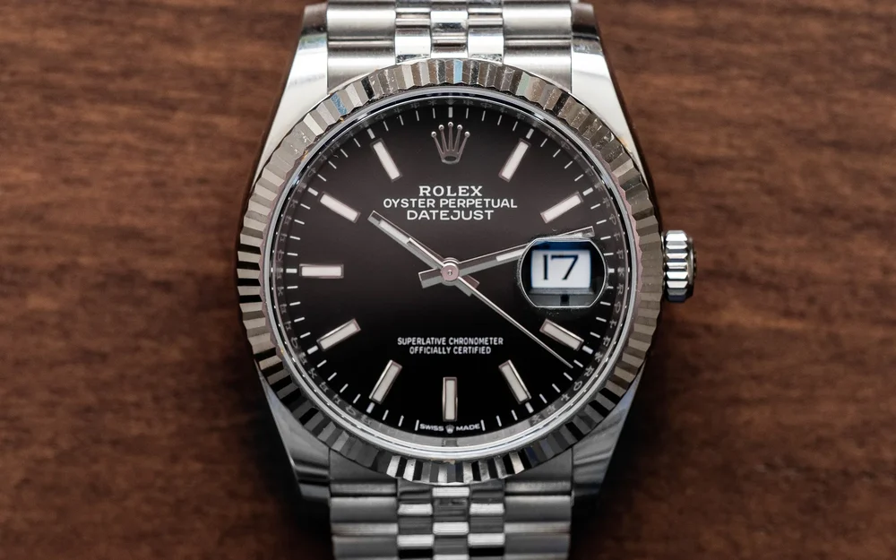 Eine Rolex Datejust mit dunklem Zifferblatt auf Holz